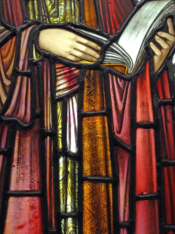Close up of Stained glass window detail, St Paul's hands holding a book.
