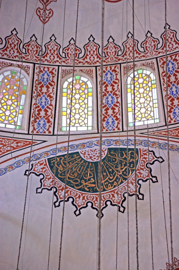 Another decorative text panel near some stained glass windows inside the Blue Mosque