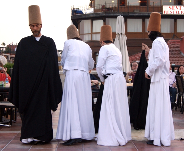 Four dervishes remove their cloaks before they begin their whirling ceremony