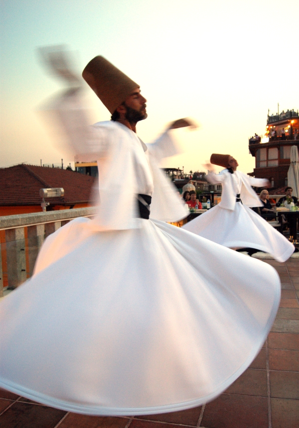 Two dervishes whirling at the climax of the ceremony, their arms outstretched.
